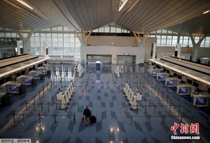 資料圖：日本東京，東京國際機(jī)場(chǎng)，一名乘客在國際航班航站樓的登機(jī)區(qū)。