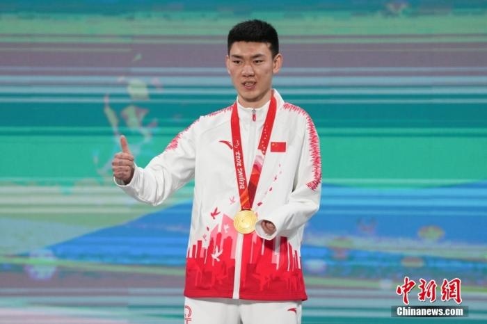3月6日，梁景怡在延慶頒獎(jiǎng)廣場(chǎng)領(lǐng)獎(jiǎng)臺(tái)上豎起大拇指。當(dāng)日，在國家高山滑雪中心舉行的北京2022年冬殘奧會(huì)殘奧高山滑雪男子超級(jí)大回轉(zhuǎn)—站姿決賽中，中國選手梁景怡奪得冠軍。 <a target='_blank' href='/'>中新社</a>記者 楊華峰 攝