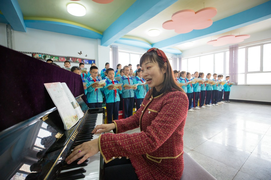 1616746926696901.jpg 3.音樂老師路霞正在與同學們排練合唱.jpg