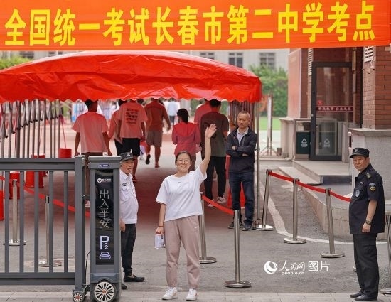 6月7日，在長(zhǎng)春市第二中學(xué)考點(diǎn)，一名考生信心滿滿進(jìn)入考場(chǎng)，并與家長(zhǎng)揮手致意。人民網(wǎng)記者 李洋攝