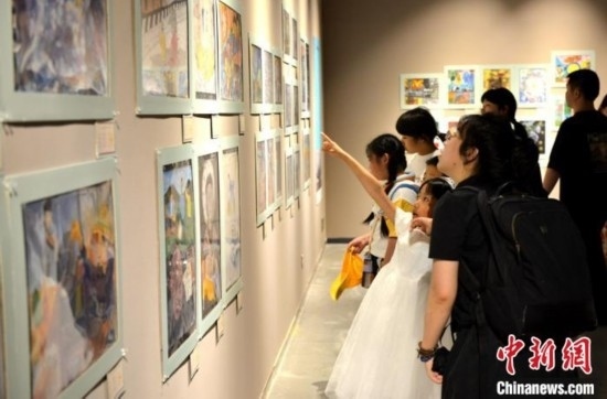 圖為家長帶著孩子參觀展覽。呂明 攝