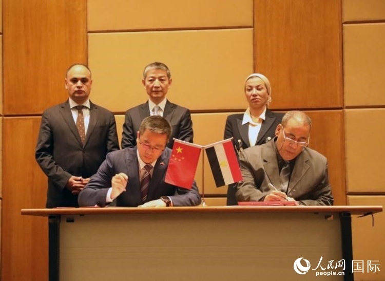 中國(guó)駐埃及使館公使張朝陽(yáng)與埃環(huán)境事務(wù)署工程和項(xiàng)目管理局局長(zhǎng)阿卜杜勒阿齊茲簽署交接證書。沈小曉攝