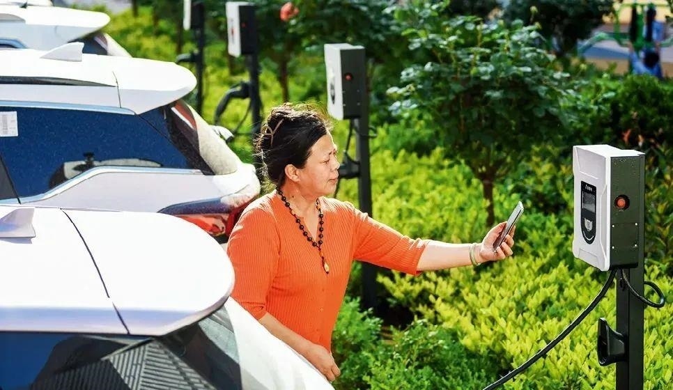 2023年5月24日，山東省膠州市新立街小區(qū)內一位居民使用電動汽車充電樁掃碼充電。該小區(qū)加裝各類智慧設備，打造“智慧社區(qū)”，為居民生活帶來便利。