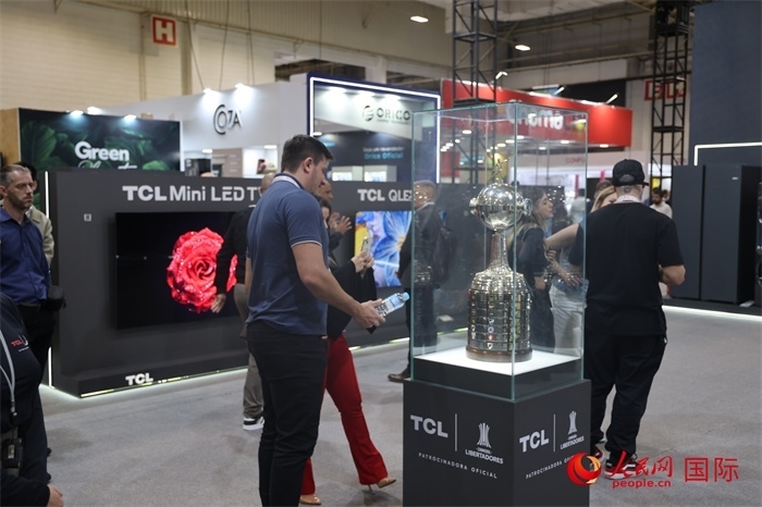 參觀者在TCL展臺前觀看南美解放者杯獎杯，據(jù)介紹，TCL是南美解放者杯（2023—2026賽季）全球官方合作伙伴。（人民網(wǎng)記者 時元皓攝）