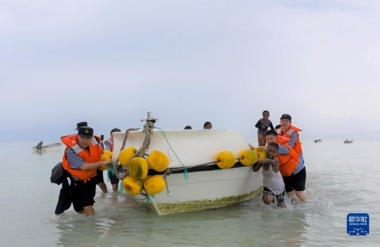 7月21日，中國海軍“和平方舟”號醫(yī)院船醫(yī)護(hù)人員涉水登島，前往基里巴斯一診療點(diǎn)。新華社記者 黎云 攝
