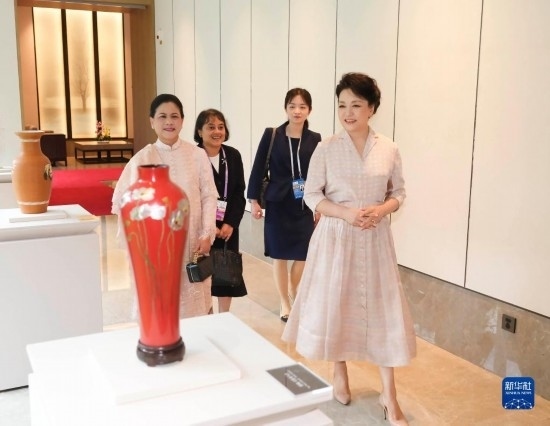 7月27日下午，國(guó)家主席習(xí)近平夫人彭麗媛在四川成都會(huì)見(jiàn)陪同印度尼西亞總統(tǒng)佐科來(lái)華出席第31屆世界大學(xué)生夏季運(yùn)動(dòng)會(huì)開(kāi)幕式并訪華的總統(tǒng)夫人伊莉亞娜。這是彭麗媛和伊莉亞娜欣賞成都特色非遺工藝品。新華社記者 丁林 攝