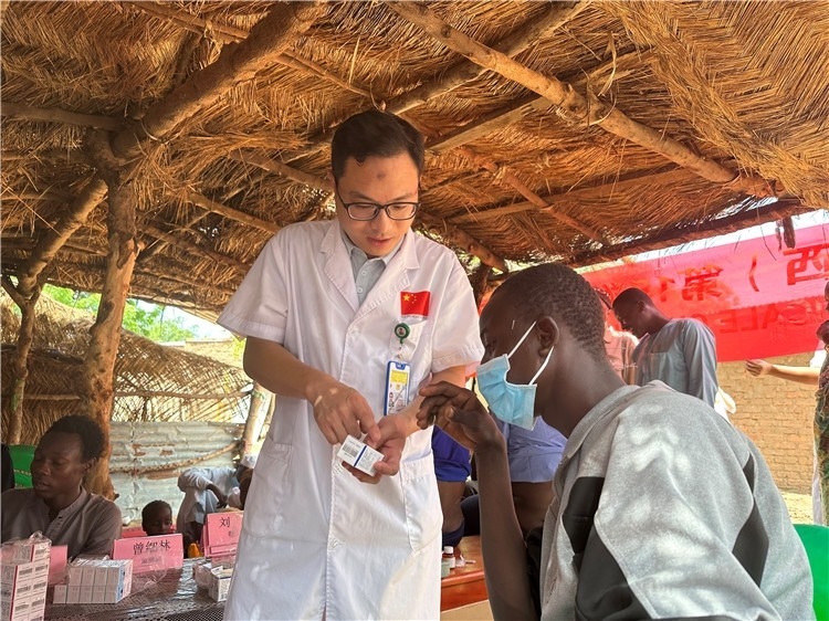 圖為南昌大學(xué)第一附屬醫(yī)院病理科主治醫(yī)師張振東為村民解說(shuō)藥品使用方法。中國(guó)駐乍得醫(yī)療隊(duì)供圖
