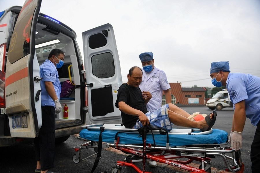 8月1日，在北京市門頭溝區(qū)妙峰山鎮(zhèn)妙峰山民族學(xué)校臨時(shí)安置點(diǎn)，北京急救中心工作人員在轉(zhuǎn)運(yùn)一名受傷村民。新華社記者 鞠煥宗 攝