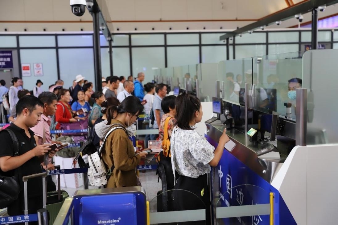 出境旅客在辦理通關(guān)手續(xù)。人民網(wǎng)記者 李發(fā)興攝
