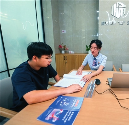 在杭州市臨安區(qū)政務服務中心的“為企服務中心”，黨員志愿者（右）解答企業(yè)主的疑問（2023年7月7日攝）。徐昱攝/本刊