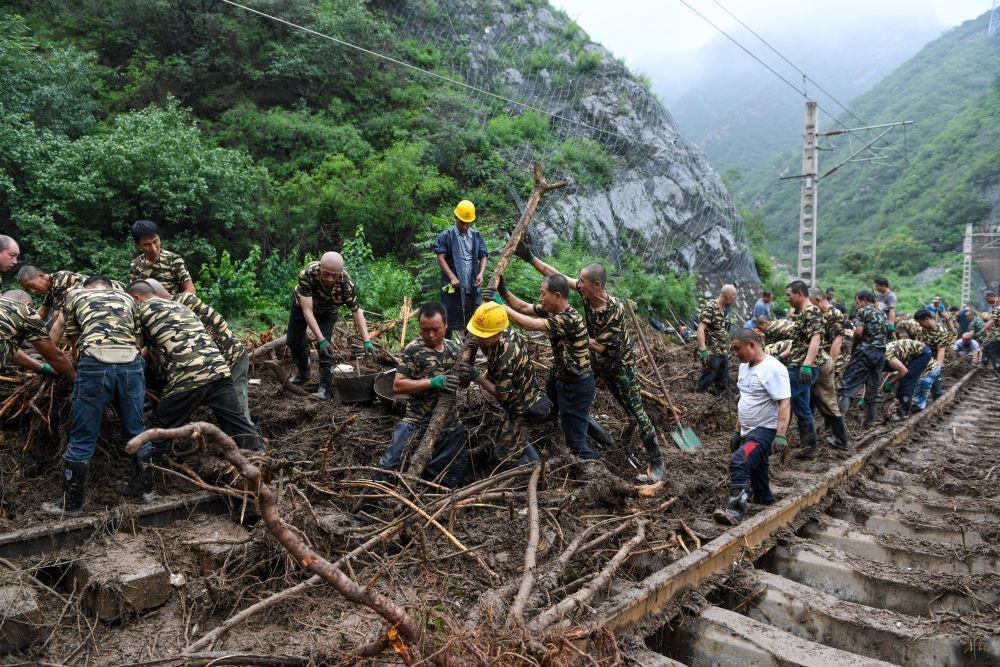 8月1日，在北京市門頭溝區(qū)水峪嘴村附近一段被阻斷的鐵路線上，中鐵六局工作人員在清理軌道上的雜物，全力恢復交通。新華社記者 鞠煥宗 攝