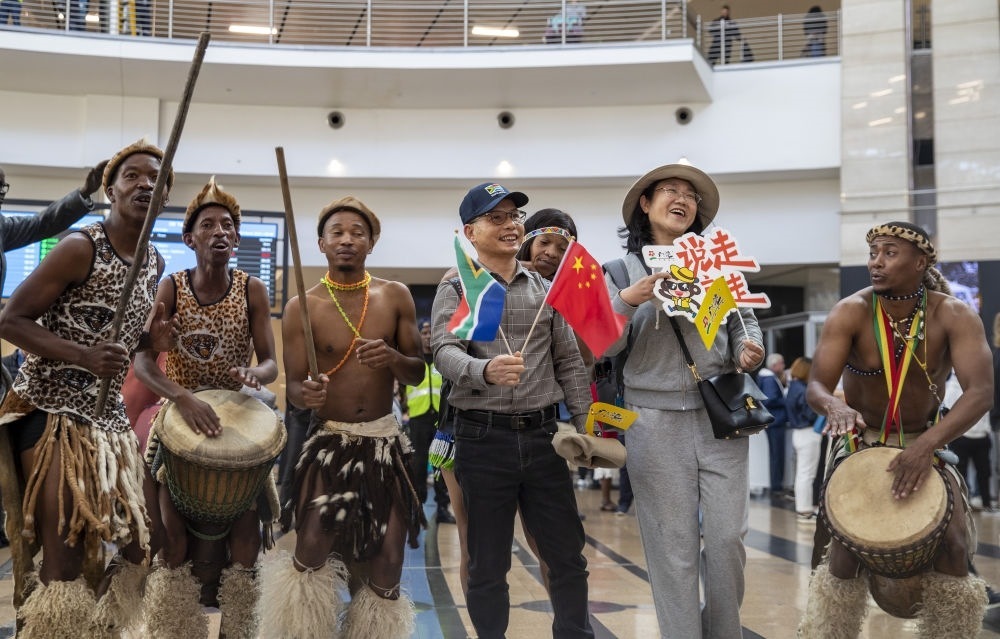 在南非約翰內(nèi)斯堡坦博國際機(jī)場，南非舞蹈演員歡迎中國試點(diǎn)恢復(fù)出境團(tuán)隊(duì)旅游后首批抵達(dá)南非的中國游客（2023年3月29日攝）。