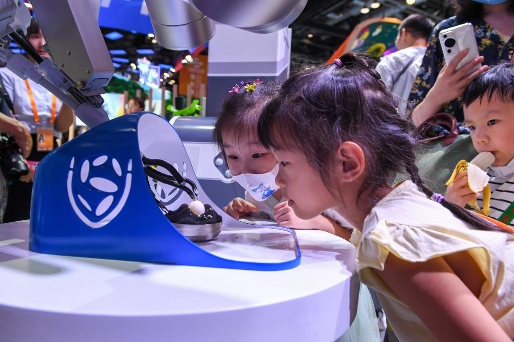 9月3日，幾名小朋友在國家會議中心觀看單孔腔鏡手術機器人展示。新華社記者 鞠煥宗 攝