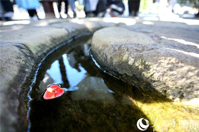 圖為水渠里流過(guò)的“桃心”蠟燭。人民網(wǎng) 盧鵬宇攝