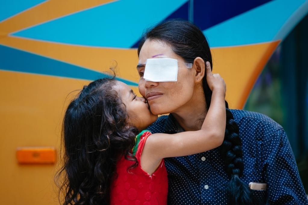 2019年3月15日，在柬埔寨磅湛省醫(yī)院，即將接受白內(nèi)障手術(shù)的患者孫美樂接受女兒的親吻祝福。在接受了中國醫(yī)療隊(duì)的白內(nèi)障義診手術(shù)后，她的視力逐步恢復(fù)，生活有了新的光明和希望。