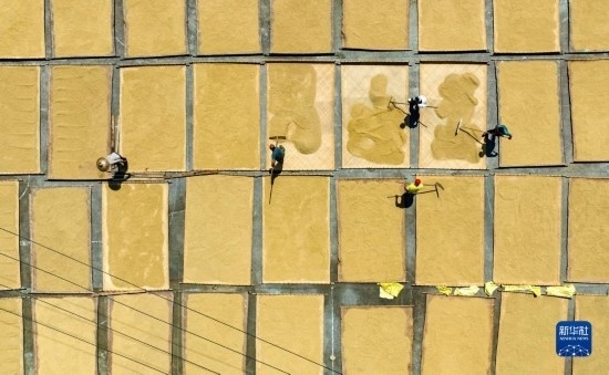 9月16日，在湖南省懷化市通道侗族自治縣萬(wàn)佛山鎮(zhèn)溪上村，村民在晾曬稻谷（無(wú)人機(jī)照片）。