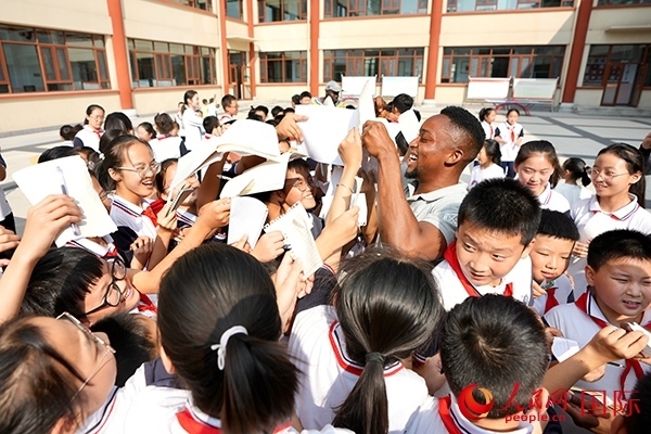 孩子們和選手互動(dòng)簽名。人民網(wǎng) 盧鵬宇攝