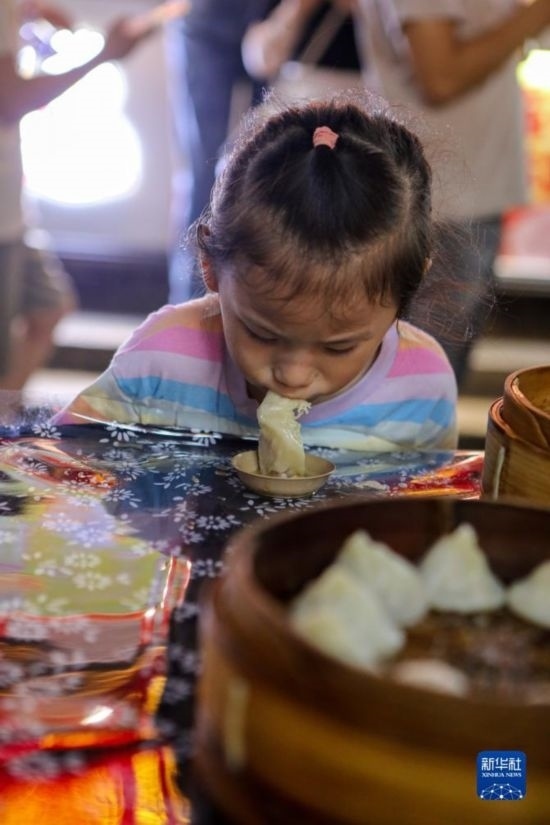 9月27日，小朋友在南翔小籠長(zhǎng)街宴上品嘗南翔小籠。