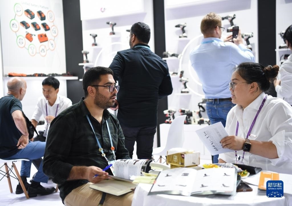 10月15日，在一家電動工具展臺，外國采購商在洽談業(yè)務(wù)。新華社記者 鄧華 攝