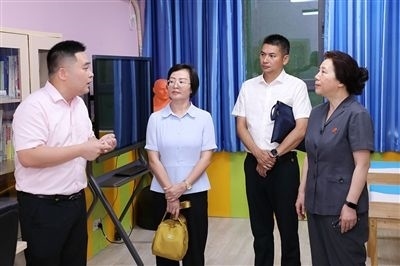 圖③：“小公民法律課堂”開講前，全國人大代表殷其龍（右二）、重慶市人大代表李自玲（左二）聽取楊家坪中學負責人關于未成年人思想教育工作情況的介紹。