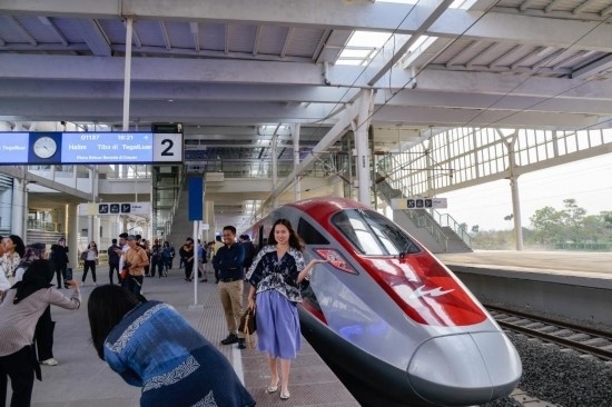  10月17日，在印度尼西亞萬(wàn)隆德卡魯爾站，乘客在站臺(tái)上和雅萬(wàn)高鐵高速動(dòng)車(chē)組列車(chē)合影。新華社記者 徐欽 攝