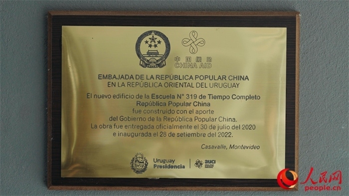 小學(xué)墻上懸掛的中國援助標識。人民網(wǎng)記者 張若涵攝