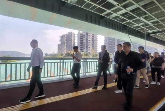 10月24日，2023“一帶一路”媒體合作論壇聯(lián)合采訪團(tuán)團(tuán)員走在清水塘大橋景觀通道上。本報(bào)記者 常雯宜攝