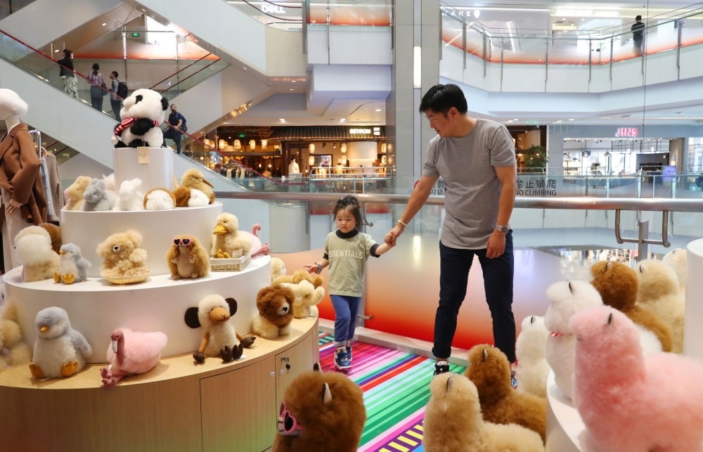 2023年11月2日，顧客在溫暖駝品牌專柜內(nèi)選購(gòu)。連續(xù)六年參加進(jìn)博會(huì)的秘魯羊駝制品品牌溫暖駝在上海市中心商場(chǎng)開設(shè)了專柜。新華社記者 方喆 攝