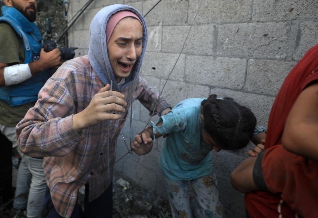 11月6日，人們從加沙地帶中部地區(qū)一處被炸難民營逃離。新華社發(fā)（亞西爾·庫迪攝）