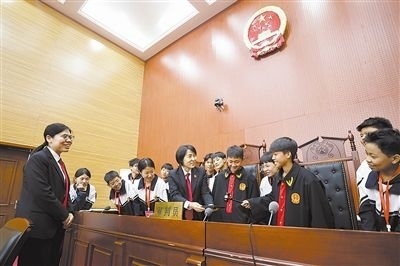 圖③：同學們穿法袍、敲法槌，爭做“小法官”。