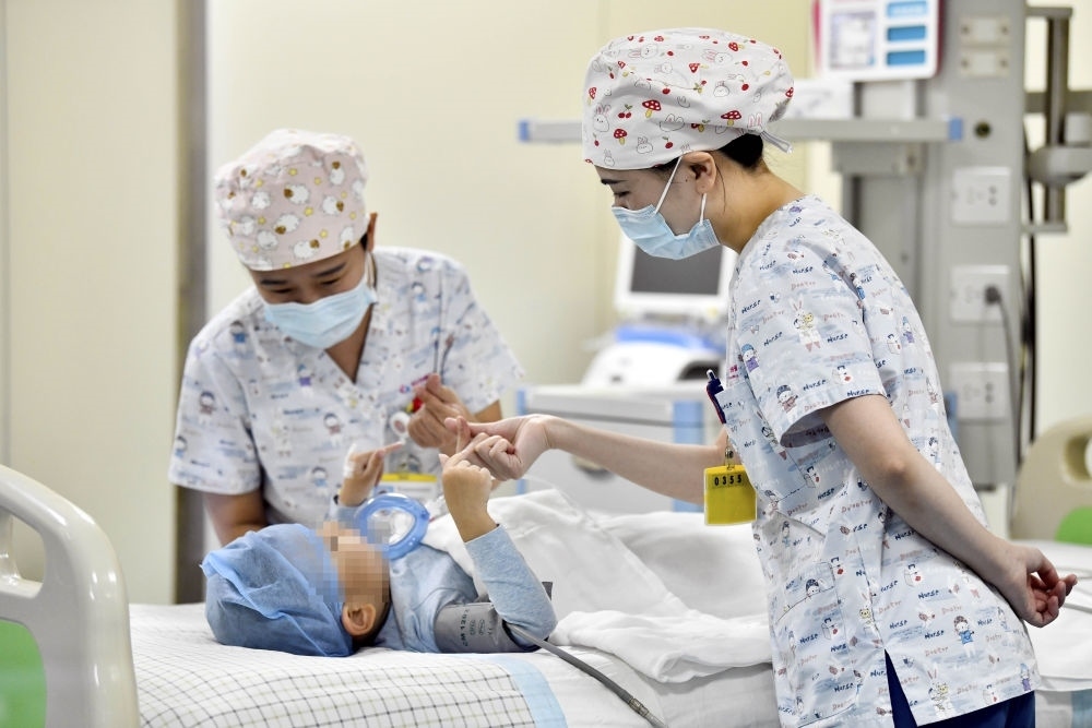 在山東省棗莊市婦幼保健院兒童ICU病房，醫(yī)護(hù)人員為完成靶向治療藥物諾西那生鈉的4歲脊髓性肌萎縮癥患兒加油鼓勁（2022年1月1日攝）。諾西那生鈉注射液是我國首個(gè)獲批治療脊髓性肌萎縮癥的進(jìn)口藥物，2019年進(jìn)入中國市場時(shí)，每針價(jià)格近70萬元。在2021年國家醫(yī)保目錄藥品談判中，以3.3萬元每針的價(jià)格進(jìn)入新版醫(yī)保藥品目錄。新華社記者 郭緒雷 攝