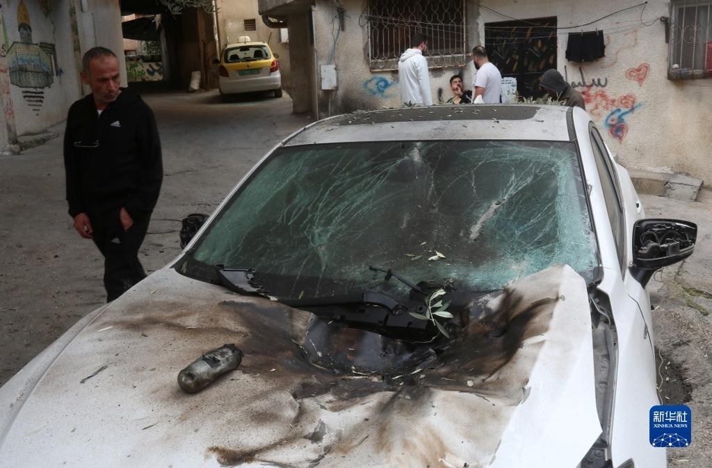 12月17日，在約旦河西岸城市圖勒凱爾姆附近的一處難民營(yíng)，人們查看在沖突中損毀的車輛。新華社發(fā)（尼達(dá)爾·艾仕塔耶?dāng)z）