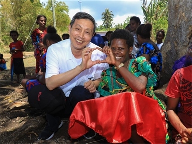 2023年12月18日，中國駐瓦努阿圖大使李名剛和前來觀看瓦努阿圖公路項目二期馬勒庫拉段移交儀式的當(dāng)?shù)鼐用窈嫌?。人民網(wǎng) 賀吉攝