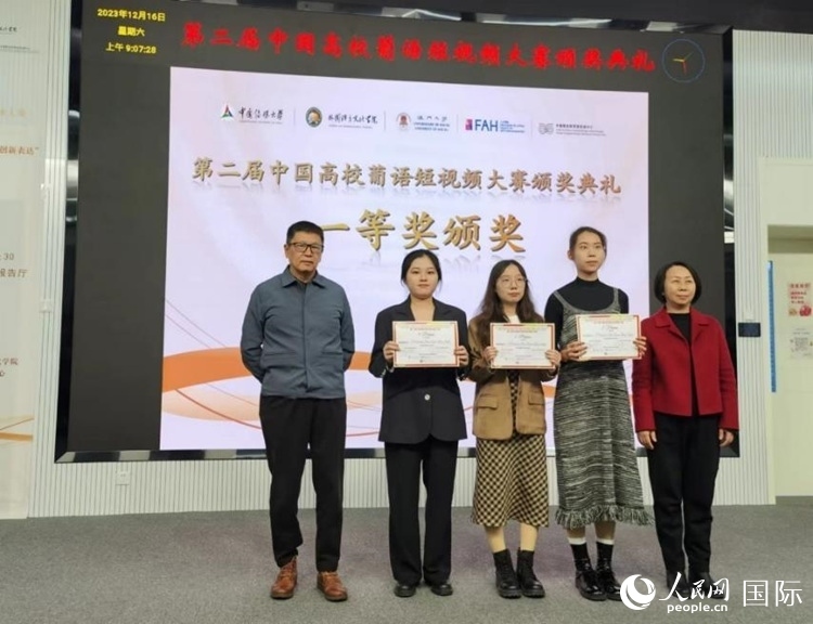 澳門大學中葡雙語教學暨培訓中心主任姚京明（左一）和中國傳媒大學外國語言文化學院院長文春英（右一）為一等獎獲得者頒獎。人民網(wǎng)記者 魯揚攝