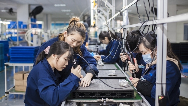 在新亞勝光電的產(chǎn)品線上，工人正進(jìn)行產(chǎn)品組建和安裝布線。受訪者供圖