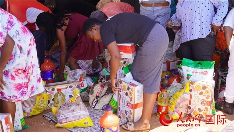 當?shù)厣鐓^(qū)家庭領(lǐng)取物資。人民網(wǎng) 張茜攝