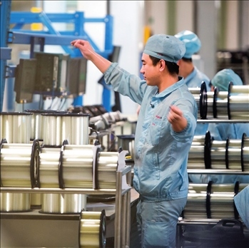 在位于武漢的長飛光纖光纜股份有限公司光纖生產(chǎn)車間內，工作人員對光纖進行檢測（資料圖片）。肖藝九攝/本刊