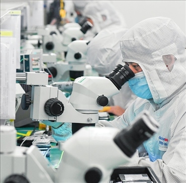 在位于武漢中國光谷的光電器件研發(fā)制造商——武漢光迅科技股份有限公司生產(chǎn)車間內，技術人員在光模塊生產(chǎn)線作業(yè)（2023年4月11日攝）。程敏攝/本刊