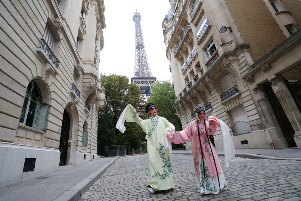 2023年9月13日，江蘇省演藝集團(tuán)昆劇院院長(zhǎng)施夏明（左）和江蘇省演藝集團(tuán)昆劇院國(guó)家一級(jí)演員孔愛(ài)萍在法國(guó)巴黎埃菲爾鐵塔附近參加昆曲快閃。新華社記者 高靜 攝