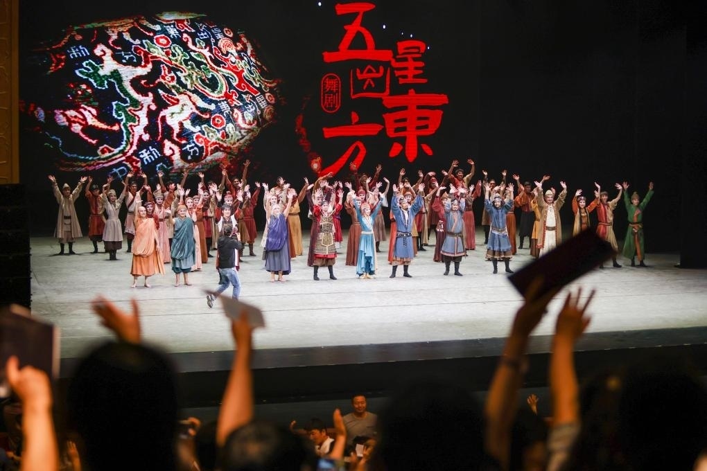 2023年7月31日，新疆和田地區(qū)新玉歌舞團(tuán)在烏魯木齊京劇院演出舞劇《五星出東方》后和觀眾互相揮手致意。這場演出是第六屆中國新疆國際民族舞蹈節(jié)的參演劇目之一，曾榮獲國家“文華獎(jiǎng)”等。新華社記者 郝昭 攝