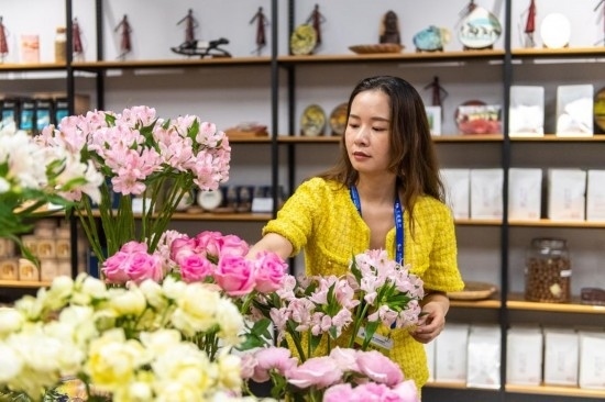 2023年7月1日，在位于湖南省長沙市的湖南高橋大市場，中非經(jīng)貿(mào)博覽會常設(shè)展館展區(qū)肯尼亞館工作人員在整理產(chǎn)自非洲的鮮花。新華社記者 陳思汗 攝