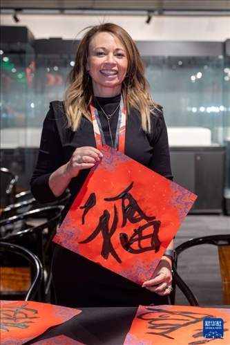 1月28日，在上海豫園舉行的民俗活動上，美國馬斯卡廷初中校長珍妮弗·李·弗里德利展示自己寫下的“?！弊?。 新華社記者 王翔 攝