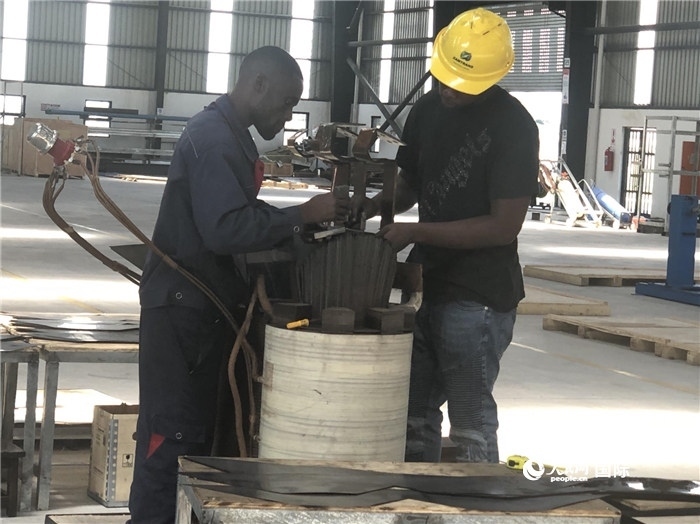 經(jīng)貿(mào)合作區(qū)廠房內(nèi)，當?shù)毓と苏诰o張作業(yè)。人民網(wǎng)記者 黃培昭攝