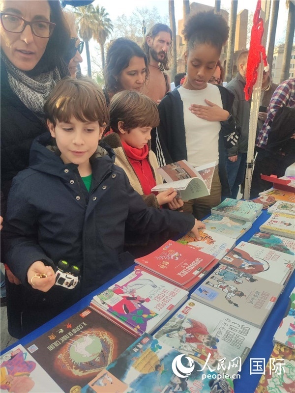 印刷精美的中國(guó)傳統(tǒng)文化叢書(shū)吸引了小游客的注意。人民網(wǎng)記者鄭彬攝