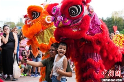 圖為舞獅表演吸引民眾合影。張興龍攝