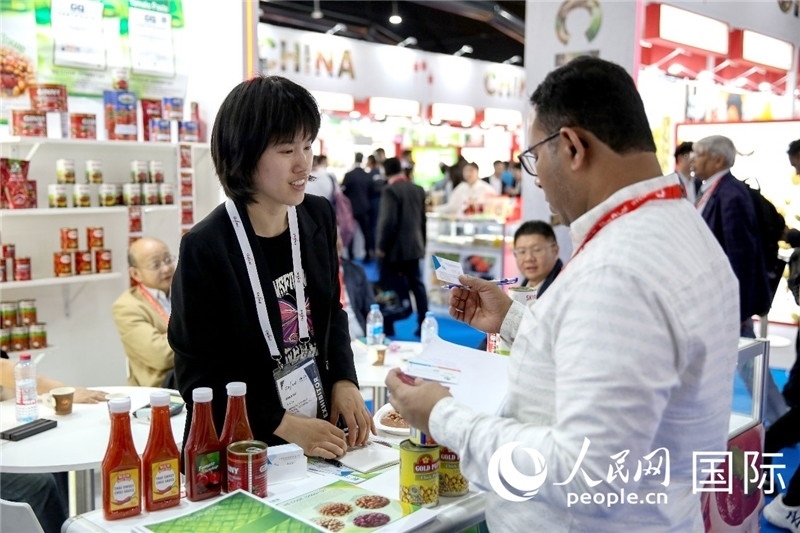 圖為中國參展企業(yè)代表與采購商交流。人民網(wǎng) 塔里克·易卜拉欣攝