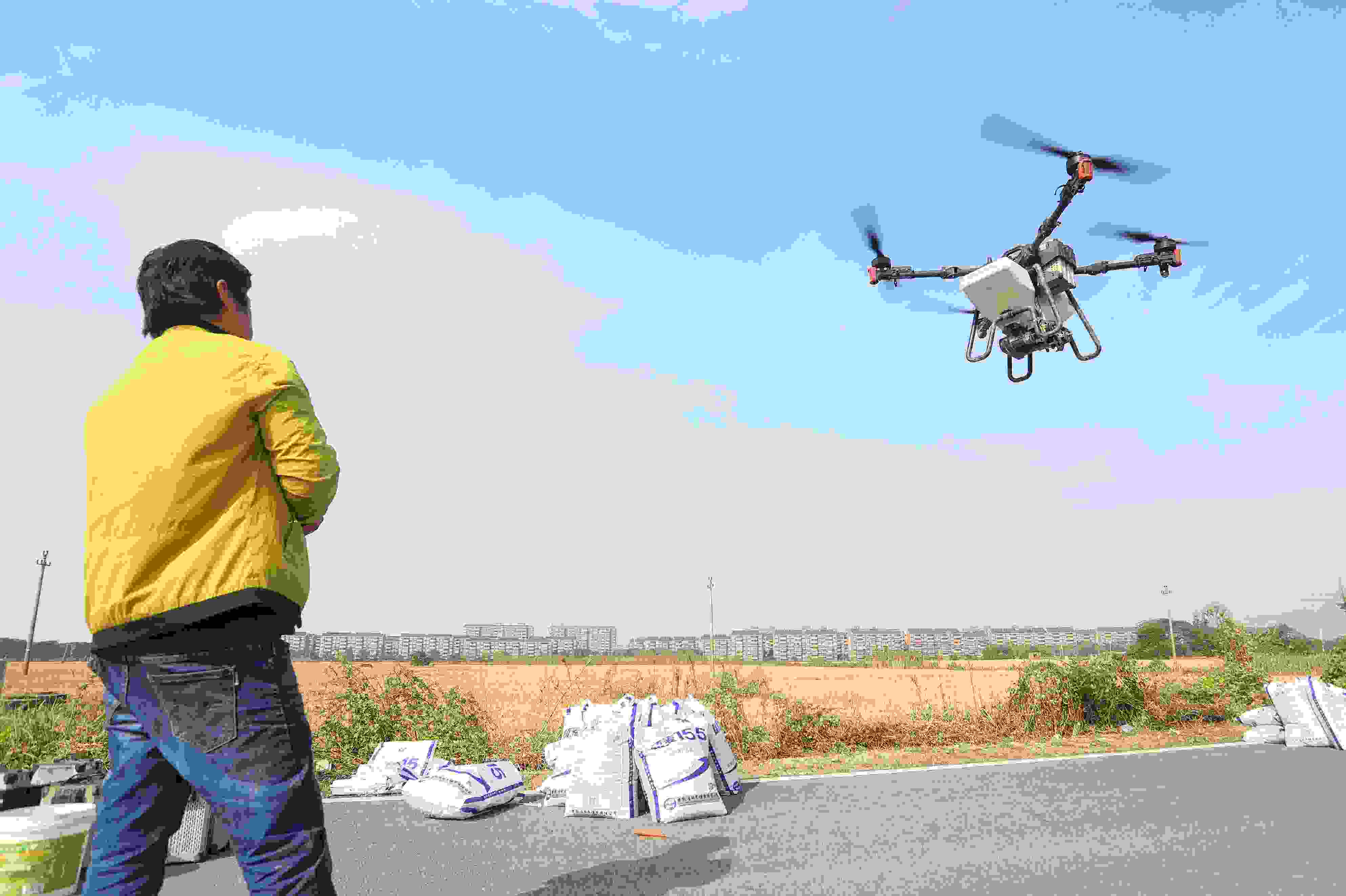 2023年11月15日，浙江嘉興，南湖區(qū)七星街道一處農(nóng)田里，農(nóng)民操縱無人機進行冬小麥飛播。