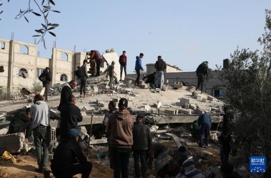  3月3日，在加沙地帶南部城市拉法，人們查看被以軍空襲破壞的建筑。新華社發(fā)（哈立德·奧馬爾攝）
