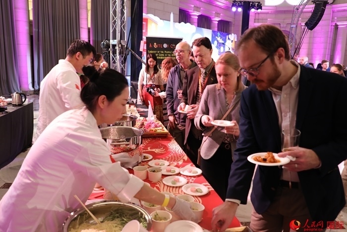 當(dāng)?shù)貢r間3月7日晚，華盛頓聯(lián)合車站廣場舉行駐美使團(tuán)“使館主廚挑戰(zhàn)賽”。圖為當(dāng)?shù)孛癖娫谥袊古_前體驗(yàn)中國美食。人民網(wǎng)記者 李志偉攝