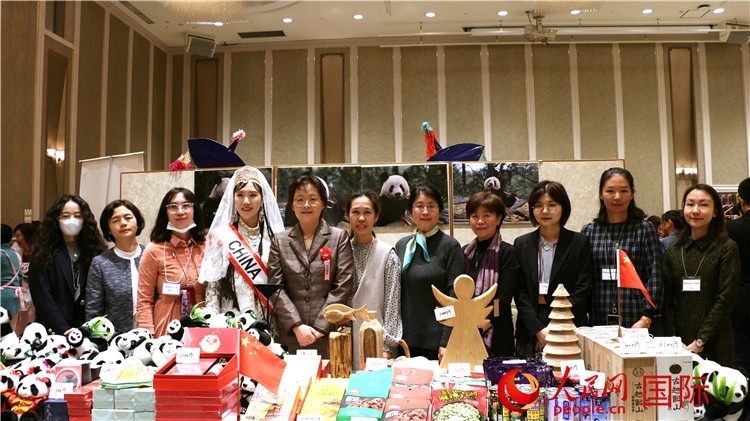 中國駐日本大使吳江浩夫人丁玥（左五）與使館人員在展位前合影留念。人民網 許可攝